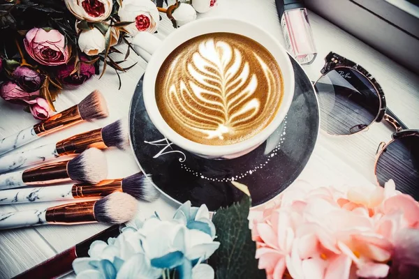 Kopp Kaffe Trä Bakgrund Med Blommor Och Sminkborstar — Stockfoto