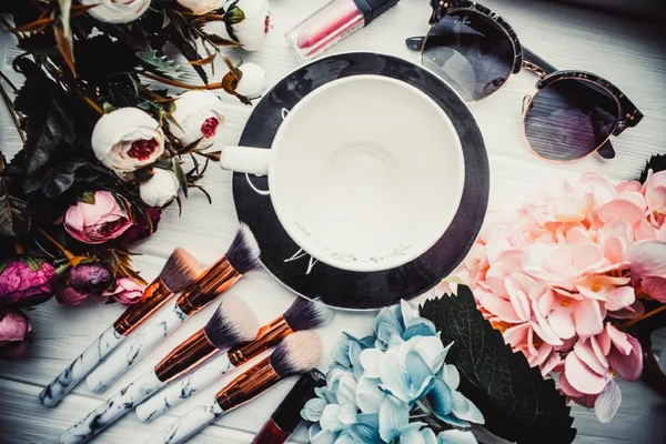 Tahta beyaz arka planda çiçekli boş bardak