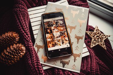 Yumuşak süveter ve beyaz ahşap arka planda telefon ve not defterleri