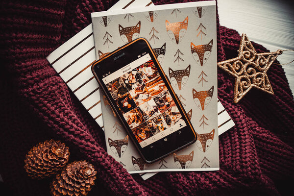 Phone and notepads on wood background with christmas decorations