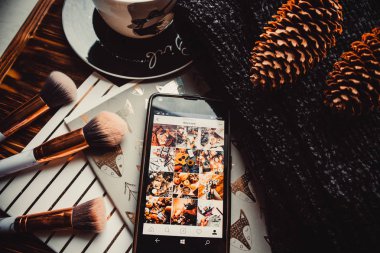 Yumuşak süveter ve beyaz ahşap arka planda telefon ve fincan