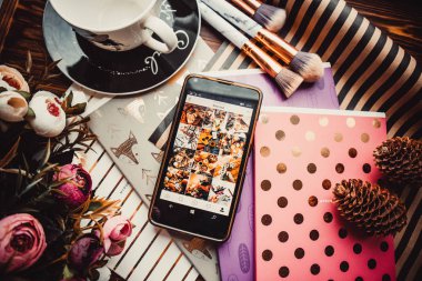 Telefon, kupa ve çiçekler tahta bir arka planda kağıt ile