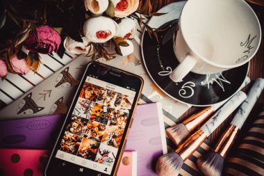 Telefon, kupa ve çiçekler tahta bir arka planda kağıt ile