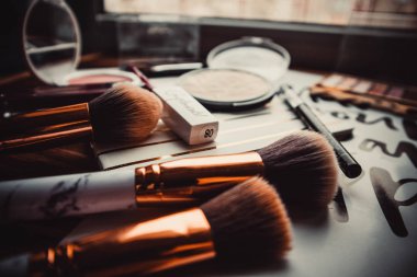 Kışın tahta arka planda pudra, göz farı ve makyaj fırçaları