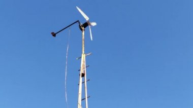 Mavi gökyüzüne karşı ev yapımı rüzgar enerjisi jeneratörü.