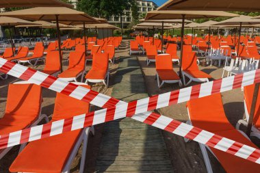 Kemer 'de güneş pansiyonları ve güneş şemsiyeleri olan arka plandaki plajda koruyucu bant.