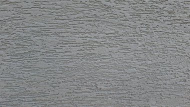 Sert yüzeyi olan desenli gri beton bir duvarın yakın çekimi.