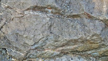 Görünür katmanları ve desenleri olan desenli bir kaya yüzeyine yakın çekim.