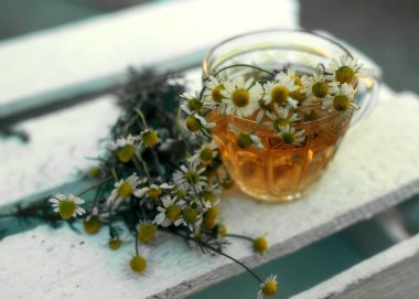 Ahşap arka planda papatya çayı..