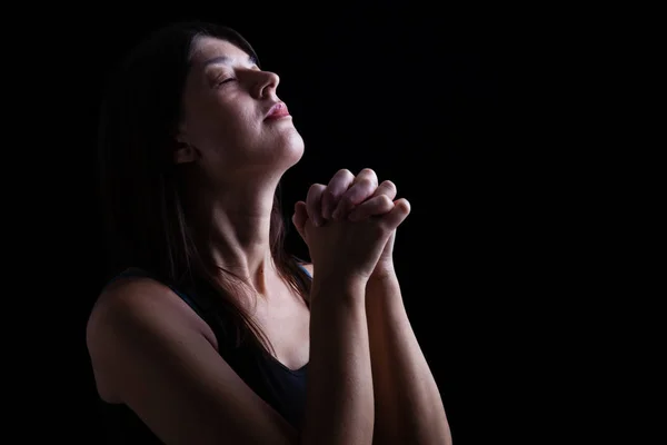 忠実な女性を祈り 手を崇拝 頭で畳むし 黒い背景上の宗教的情熱に目を閉じたをクローズ アップ 祈りおよび精神性のためのコンセプト — ストック写真