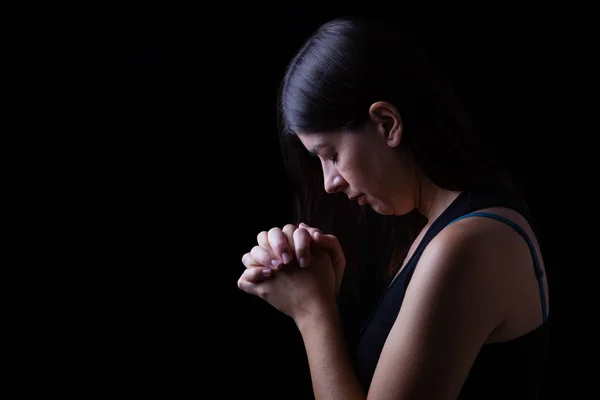 祈って 忠実な女性の手ダウン頭と黒い背景上の宗教的熱情の閉じた目の神への崇拝に折り返されています 祈りおよび精神性のためのコンセプト — ストック写真