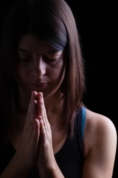 祈っていると 頭を下に 黒い背景上の宗教的熱情の閉じた目の礼拝で折り畳まれた手で忠実な運動の女性 祈りおよび精神性のためのコンセプト — ストック写真