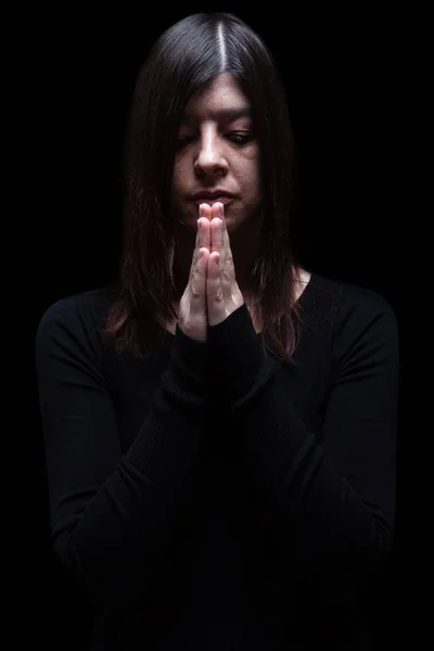 祈っていると 神への崇拝に折り畳まれた手で女性を喪頭と閉じた目に苦しむ 黒い背景に 悲しみのための概念を悼む うつ病 — ストック写真