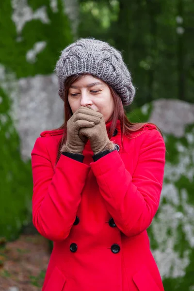 Молодая Женщина Дрожит Холода Дует Горячим Воздухом Руки Лес Красном — стоковое фото