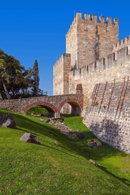 Lisbon, Portugal - February 01, 2017: Castelo de Sao Jorge aka Saint George Castle. Entrance of the Castelejo aka keep with the moat, watchtowers, battlements, ramparts.  clipart