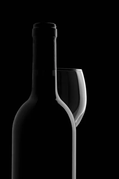 优雅的葡萄酒瓶和在黑色背景中的红酒杯 — 图库照片