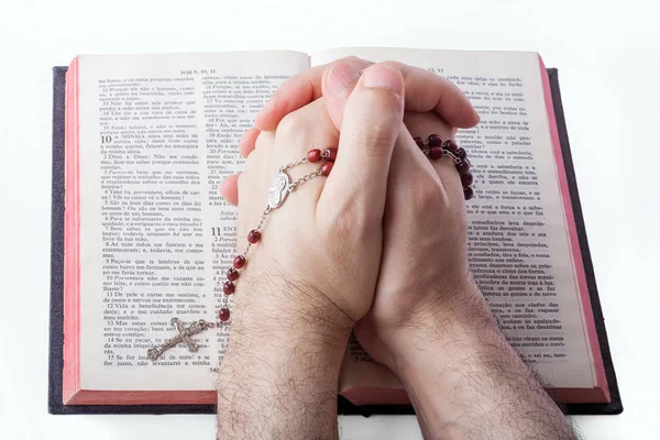 男性の手が開いている古い聖書にロザリオを保持している祈りに閉鎖 — ストック写真