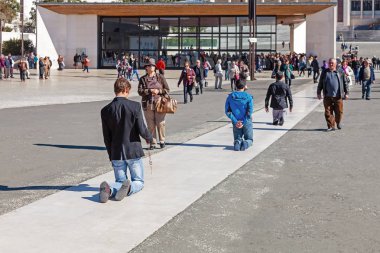 Sanctuary of Fatima, Portugal, March 07, 2015 - Devotees walk the Penitential Path on knees for vows made to Our Lady after the fulfillment of requests. Fatima is a major Marian Shrine for Catholics clipart