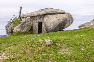 Casa do Penedo, a house built between huge rocks on top of a mountain in Fafe, Portugal. Commonly considered one of the strangest houses in the world. clipart