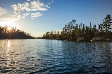Kuzey Minnesota Gölü Sınır Suları yakınında Sonbahar boyunca gün batımında kayalar ve çamlarla