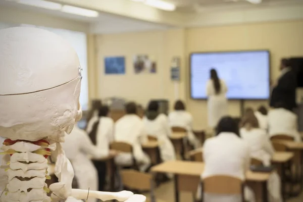 在教室里的学生的背景上有锁的骷髅 — 图库照片