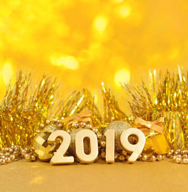 2019 yılı altın altın Noel süslemeleri bir bokeh arka planda arka plan üzerinde rakamlar