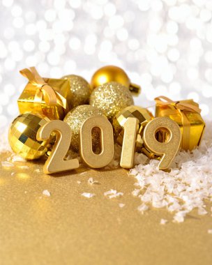 2019 yılı altın altın Noel süslemeleri bir bokeh arka planda arka plan üzerinde rakamlar