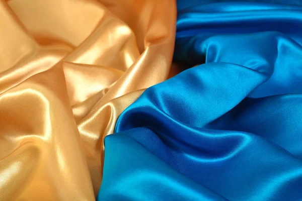 Natural golden and blue satin fabric as background texture