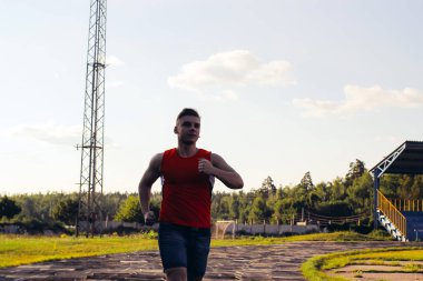 Stadyumda koşan atletik genç adam.