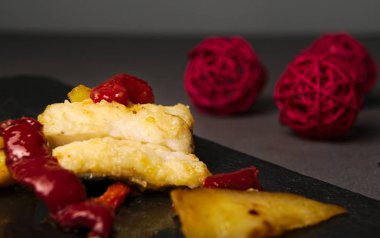 Lezzetli morina ve kırmızı biber kayrak kurulu ve arka kırmızı dekorasyon topları ile gri Tekstil