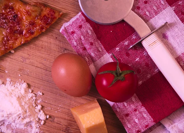 Natürmort maddeler dahil Ayrıca peynir, domates, un, yumurta ve bir parça pizza, pizza pizza kesici kırmızı kumaş üzerinde yemek pişirmek için