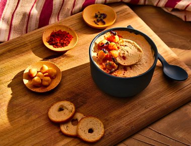 75 derece natürmort mavi kase humus dahil olmak üzere tam kırmızı biber, nohut, lavanta ve ekmek, ahşap masa, üzerine ışık ve kırmızı bez güneş