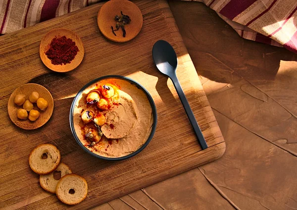 Genel gider natürmort mavi kase humus dahil olmak üzere tam kırmızı biber, nohut, lavanta ve ekmek, ahşap masa, üzerine ışık ve kırmızı bez güneş
