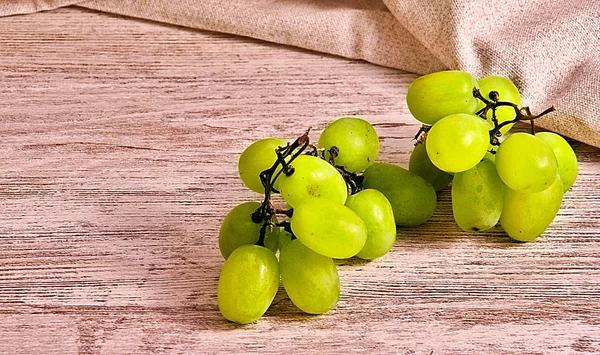 Yeşil üzüm gurup ahşap tahta ve kahverengi kumaş üzerinde Kapat