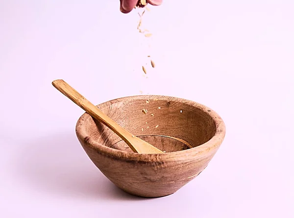 45 derece fotoğraf ahşap kase, beyaz arka plan ve müsli bırakarak en üstündeki parmak