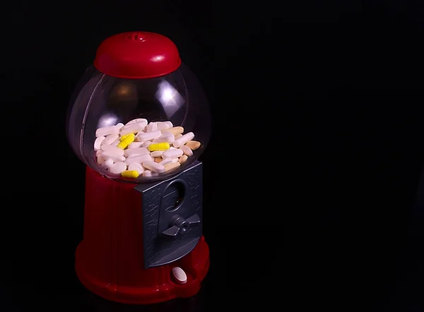 45 derece fotoğraf kırmızı plastik tatlı makinenin hapları, bazı beyaz onları ve bazıları ise sarı ve beyaz bir hap çıkmak içinde dolu