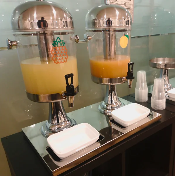 Two juice containers in hotel buffet for breakfast