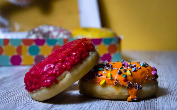 Two colored donuts over wood table