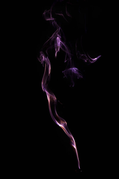 Close up picture of incense smoke illuminated, creating special forms