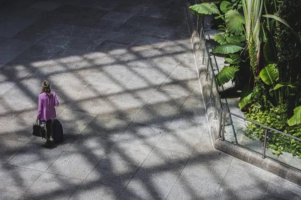 Tourist at station next to indoor garden