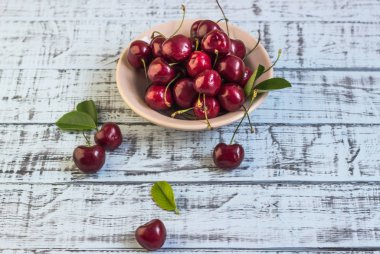 Ahşap arka planda taze kiraz tabağı. Taze kirazlar. Tatlı kirazlar.