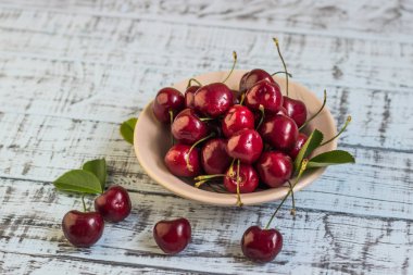 Ahşap arka planda taze kiraz tabağı. Taze kirazlar. Tatlı kirazlar.