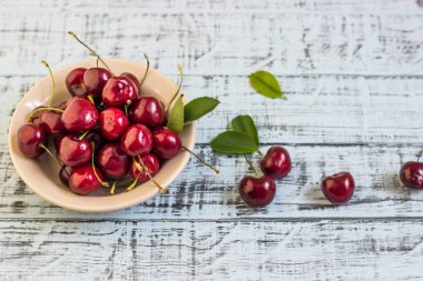 Ahşap arka planda taze kiraz tabağı. Taze kirazlar. Tatlı kirazlar.