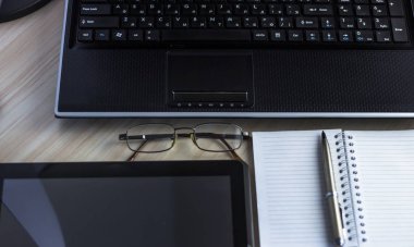 Yazı alanı olan ofis çalışma yeri ofis malzemeleri olan beyaz ahşap masa tablet, masaüstü bilgisayar ve kitap, üst görünüm, ışık ötesi.