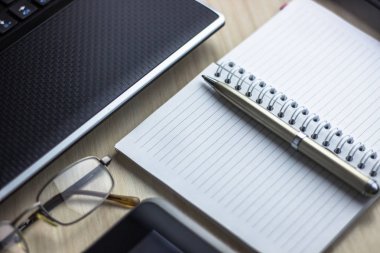 Yazı alanı olan ofis çalışma yeri ofis malzemeleri olan beyaz ahşap masa tablet, masaüstü bilgisayar ve kitap, üst görünüm, ışık ötesi.