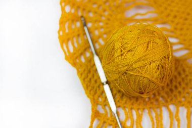 Sarı dantel tığ işi, iş parçacığı ve kroşe topları beyaz arka plan üzerinde kanca.
