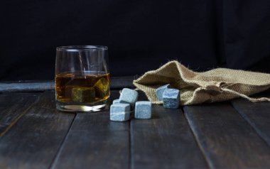Ahşap bir masa içkiler soğutma için taşlarla bardakta viski