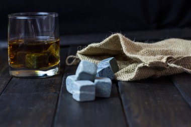 Ahşap bir masa içkiler soğutma için taşlarla bardakta viski