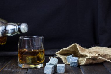 Ahşap bir masa içkiler soğutma için taşlarla bardakta viski