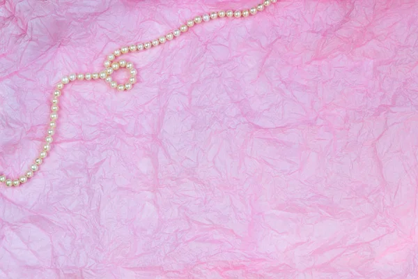 Pearl necklace on pink wrinkled paper texture background — Stock Photo, Image